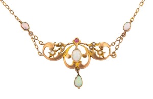 An antique 9ct gold negligee necklace, set with four polished solid opals, seed pearls and ruby, circa 1910, the pendant 3.5cm wide, the chain 46cm long, 6 grams total