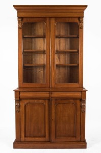 An antique Australian cedar bookcase with ogee moulded pediment, two glazed doors and three adjustable shelves, 19th century, 229cm high, 117cm wide, 44.5cm deep