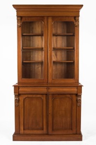 An antique Australian cedar bookcase with ogee moulded pediment, two glazed doors and three adjustable shelves, 19th century, 229cm high, 117cm wide, 44.5cm deep