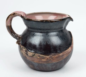 PHILIPPA JAMES brown glazed pottery jug with pink interior, adorned with gumnuts and leaf with branch handle, incised "Philippa James" , 14cm high, 17.5cm wide