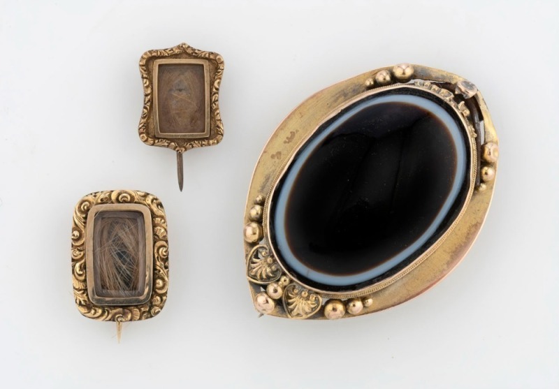 Two Georgian mourning brooches (one dated 1835), together with an antique agate brooch, 19th century, (3 items), the largest 5cm wide