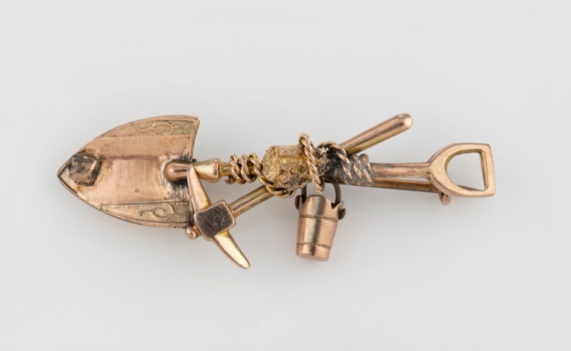 A 9ct gold brooch with cross pick and shovel, rope and bucket with gold nugget specimens, (damaged), ​​​​​​​4.7cm wide, 3.6 grams