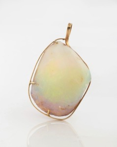A solid opal fossilized mussel shell bivalve mounted in yellow gold as a pendant, circa 1970, 5cm high