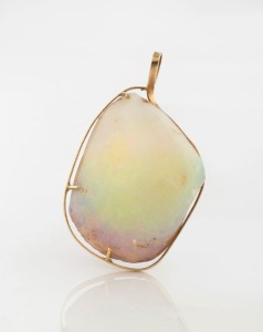 A solid opal fossilized mussel shell bivalve mounted in yellow gold as a pendant, circa 1970, ​​​​​​​5cm high