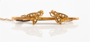 An antique 15ct gold insect brooch adorned with two flies, set with seed pearls, 19th century, stamped "15ct", 4cm wide, 3 grams