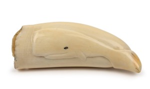 A scrimshaw whale's tooth with three dimensional carved sperm whale; ​​​​​​​has been holed for use as a necklace, 12cm high