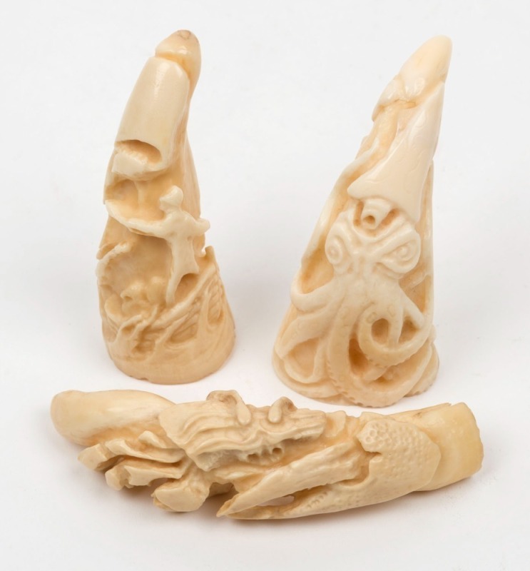 Three whales tooth ornaments, all carved in deep relief, the largest 8cm high