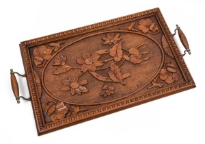 A folk art timber tray with carved horseshoe and floral motif, 19th/20th century, 62cm across the handles