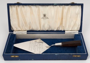 An Australian silver presentation trowel with timber handle in original presentation box by Hardy Bros., engraved "Presented To The Hon. John Cain M.L.A. Premier Of Victoria. By Heyfield War Memorial Com. Saturday 19th Feb. 1955. Jas. Anderson President. M.J. Bourke Hon. Sec.", 28cm long