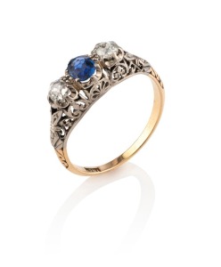 An antique 18ct gold ring, set with a fine quality blue sapphire flanked by two rose cut diamonds mounted in white gold, 2.9 grams total