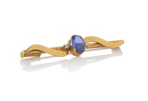 An 18ct yellow gold bar brooch, set with a pale blue Ceylonese sapphire, flanked with two white diamonds, stamped "18ct", 5cm wide, 4.2 grams