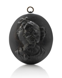 An antique jet locket with cameo profile portrait of a lady, the interior handsomely carved with scrolling motif, circa 1860s, 4.5cm high