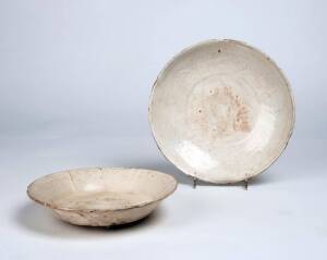 A Cizhou six-lobbed dish covered with a thick creamy glaze, Song Dynasty, and a second similar dish with moulded design, Yuan Dynasty, 12th to 14th century, 18cm and 20.5cm diameter