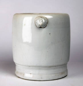 A heavy white glazed stoneware vessel with two ram&rsquo;s heads at the top, 24cm high, 26cm wide