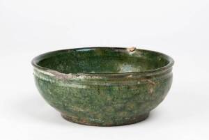 A small lead glazed green ware bowl, Han Dynasty 206BC-220AD, supported on a flat iron red base. 14.5cm diameter