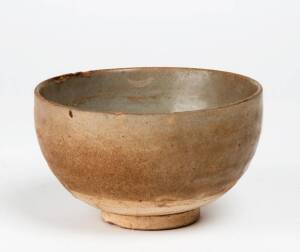 An unusual heavy stoneware celadon bowl, late Tang Dynasty, circa 9th century, supported on a flat foot, three spur marks in the centre. 13.8cm diameter