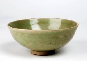 A Chinese Longquan celadon bowl, Yuan Dynasty 1280-1368, with a clear pale green glaze, an impressed character under the glaze in the centre.18.7cm diameter