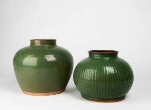 Two Chinese green glazed stoneware jars, Guandong ware, with iron red concave bases, 19th/early 20th century. 18.5cm and 23cm high