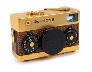 FRANKE & HEIDECKE: 1979 Rollei 35S compact camera [#0046/1500], in gold-plated edition marking the 60th anniversary of the Rollei company. In addition to being plated in 24-carat gold, the body is covered in lizard skin, bearing a uniquely numbered plate 