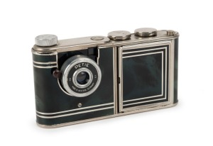 WALTER KUNIK: Petie Vanity subminiature camera for 14x14 exposures on 16mm film, circa 1956, with chrome and marble-green body. Front door opens to reveal mirror and original powder pad, which is present.