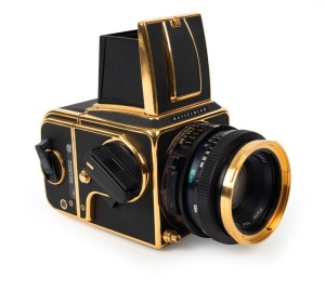 HASSELBLAD: 1985 Hasselblad 2000FC/M '100 Years in Photography' limited-edition medium-format SLR camera [#RI 1520698 & #RI 3264751] in black and gold, with Planar 80mm f2.8 lens [#5872721]. Bears a plaque indicating that this camera is number 227 of 1500