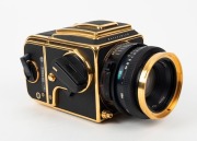 HASSELBLAD: 1985 Hasselblad 2000FC/M '100 Years in Photography' limited-edition medium-format SLR camera [#RI 1520698 & #RI 3264751] in black and gold, with Planar 80mm f2.8 lens [#5872721]. Bears a plaque indicating that this camera is number 227 of 1500 - 3