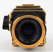 HASSELBLAD: 1985 Hasselblad 2000FC/M '100 Years in Photography' limited-edition medium-format SLR camera [#RI 1520698 & #RI 3264751] in black and gold, with Planar 80mm f2.8 lens [#5872721]. Bears a plaque indicating that this camera is number 227 of 1500 - 8