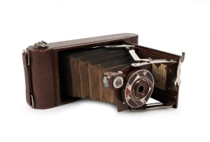 KODAK: Gift No. 1A vertical-folding camera, circa 1930, in brown leather, decorated with metal Art-Deco inlay on front door. Presented in original cedar box, which repeats the beautiful Art-Deco design present on the camera itself.