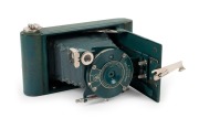 KODAK: Vanity Kodak Ensemble vertical-folding camera [#34553] in green finish, circa 1928,&nbsp;complete with original lipstick, powder compact, mirror, and money pocket in leather case with strap,&nbsp;together with&nbsp;instructions, original owner's card, and&nbsp;maker's