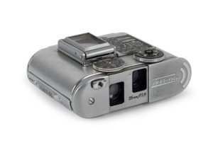 CONCAVA: Chrome-body Tessina L subminiature camera [#166859], circa 1985, with Tessinon 25mm f2.8 lens. Presented in maker's box with dusting brush accessory.
