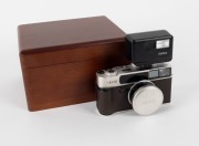 KONICA: 1994 anniversary-edition&nbsp;'Century of Camera Excellence' Hexar Rhodium [#0100003] viewfinder camera, with Hexar&nbsp;35mm f2 lens. Presented in wooden, felt-lined&nbsp;maker's box, together with&nbsp;metal&nbsp;lens cap,&nbsp;HX-14 Auto flash unit [#2039631], leather strap - 2