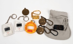 LEITZ: Eight Leica promotional keychains made of various materials, one in its original Leica-branded grey felt pouch. (8 items)