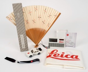 LEITZ: Various original Leica-branded promotional items, including a folding hand fan in original box, a toy car, and a calculator, among other items. (6 items)