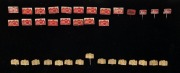 LEITZ: Thirty-six Leica-branded metal pins, twenty-one in red and fifteen in gold, presented on a black Leica-branded pinboard.&nbsp;(37 items) - 2