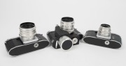 KAMERA-WERKST&Auml;TTEN: Three 1950s&nbsp;SLR cameras - one Praktica FX with Tessar&nbsp;50mm f2.8 lens [#4779778] and spring-driven motor transport attachment, one Praktica FX2 with Biotar&nbsp;58mm f2 lens [#4419090], and one Praktica FX2 with Trioplan&nbsp;50mm f2.9 lens [#168 - 4