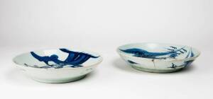 Two Chinese saucer dishes, one decorated in under-glaze blue and copper red 27.3cm diameter, the second with an under-glaze blue dragon, 28.2cm diameter, both early 18th century