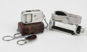 MINOX: Two Minox camera attachments - one 1953 Minosix exposure meter in leather case with wrist chain, and one circa 1955 binocular telephoto clamp. (2 items)