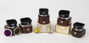 FRANKE & HEIDECKE: Two Rollei accessory kits each containing one lens hood and two lens filters, both in original leather pouches, with one in maker's box. Also three Rollei lens hoods of various sizes, likewise in their original leather pouches, with one