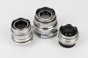 VOIGTLÄNDER: Three lenses - one Dynaron 100mm f4.5 [#3805293], one Skoparex 35mm f3.4 [#4413244] with lens cap, and one Dynaret 100mm f4.8 [#4291813]. (3 lenses)