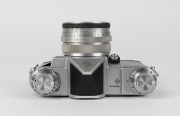 KAMERA-WERKST&Auml;TTEN: Circa 1958 Praktina IIa SLR camera [#107 565] with Flexon 50mm f2 lens {#5471997] and front lens cap. Together with maker's box, leather body casing, lens hood, rapid-wind lever accessory, and instruction booklet. - 5