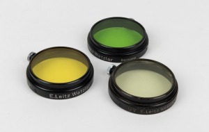 LEITZ: Three circa 1931 Leica A36 lens filters - one FIGAM medium yellow in original plastic case, one FIPOS green, and one FIOLOA UVa. (3 items)