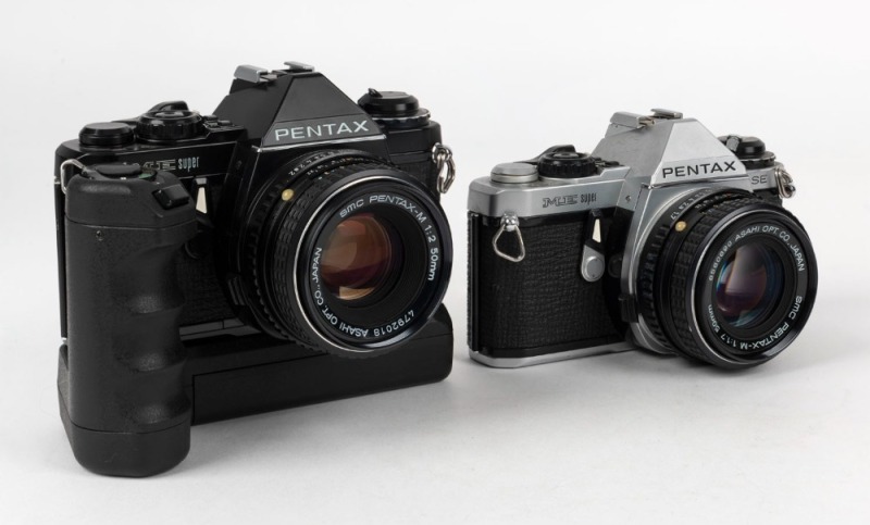 ASAHI KOGAKU: Two circa 1980 Pentax ME Super SLR cameras - one black-body with SMC Pentax-M 50mm f2 lens [#4792018] and Pentax Winder ME II attachment, the other in chrome [#2746139] with SMC Pentax-M 50mm f1.7 lens [#6560690]. (2 cameras)