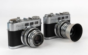 DIAX: Two circa 1956 Diax IIb triple-viewfinder cameras - one [#131992] with Xenon 50mm f2 lens [#4726421] and metal lens hood, and one [#134455] with Xenar 50mm f2.8 lens [#4772876] and lens cap. (2 cameras)