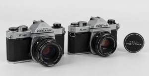 ASAHI KOGAKU: Two circa 1976 Pentax K1000 SLR cameras - one [#7659026] with SMC Pentax-M 50mm f2 lens [#3038809] and lens cap, and one unusual example without body serial number, with SMC Pentax 55mm f2 lens [#1634529]. (2 cameras)