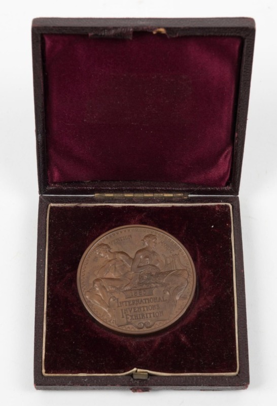 1885 INTERNATIONAL INVENTIONS EXHIBITION prize medal in bronze, "VICTORIA REGINA" and veiled head of Queen Victoria to obverse; reverse with a seated male holding an olive branch and compasses and a female holding a lyre above the inscription tablet. Supe