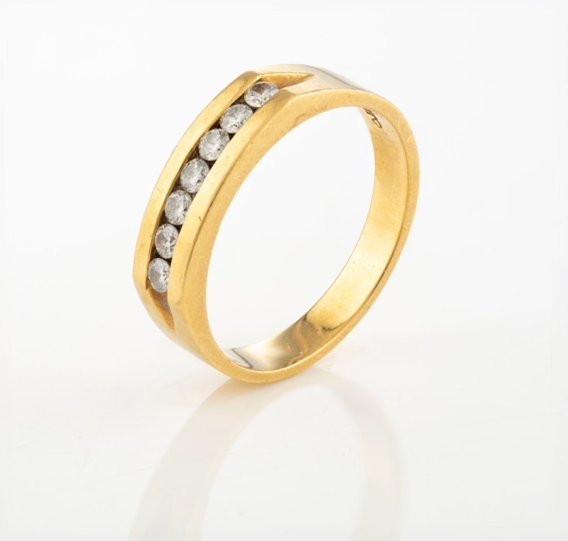 An 18ct yellow gold ring, set with a row of seven brilliant cut white diamonds, stamped "750, M.D.T.", ​​​​​​​8 grams total