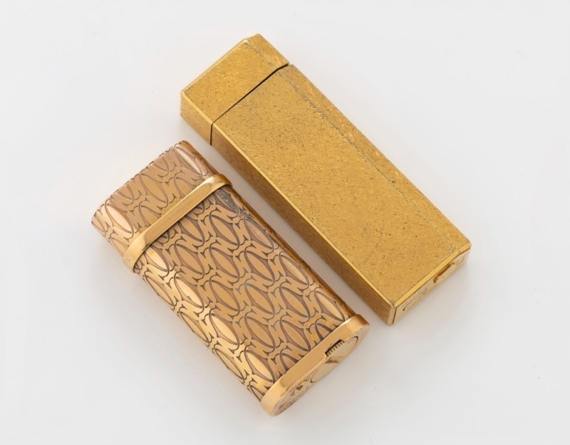 CARTIER two gold plated cigarette lighters, ​​​​​​​both stamped "Cartier", 6cm and 7cm high