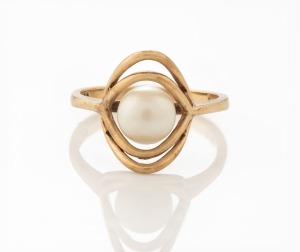 A 14ct yellow gold ring in the modernist style, set with a cultured pearl, stamped "14K, P.C.", 2.9 grams