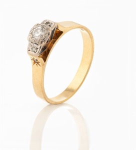 An 18ct yellow gold ring, set with three diamonds mounted in platinum, stamped "18ct, PALL", 4.3 grams