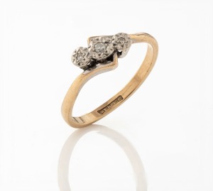 A 9ct yellow gold ring, set with three white diamonds mounted in platinum, stamped "9ct, PLAT", 2 grams